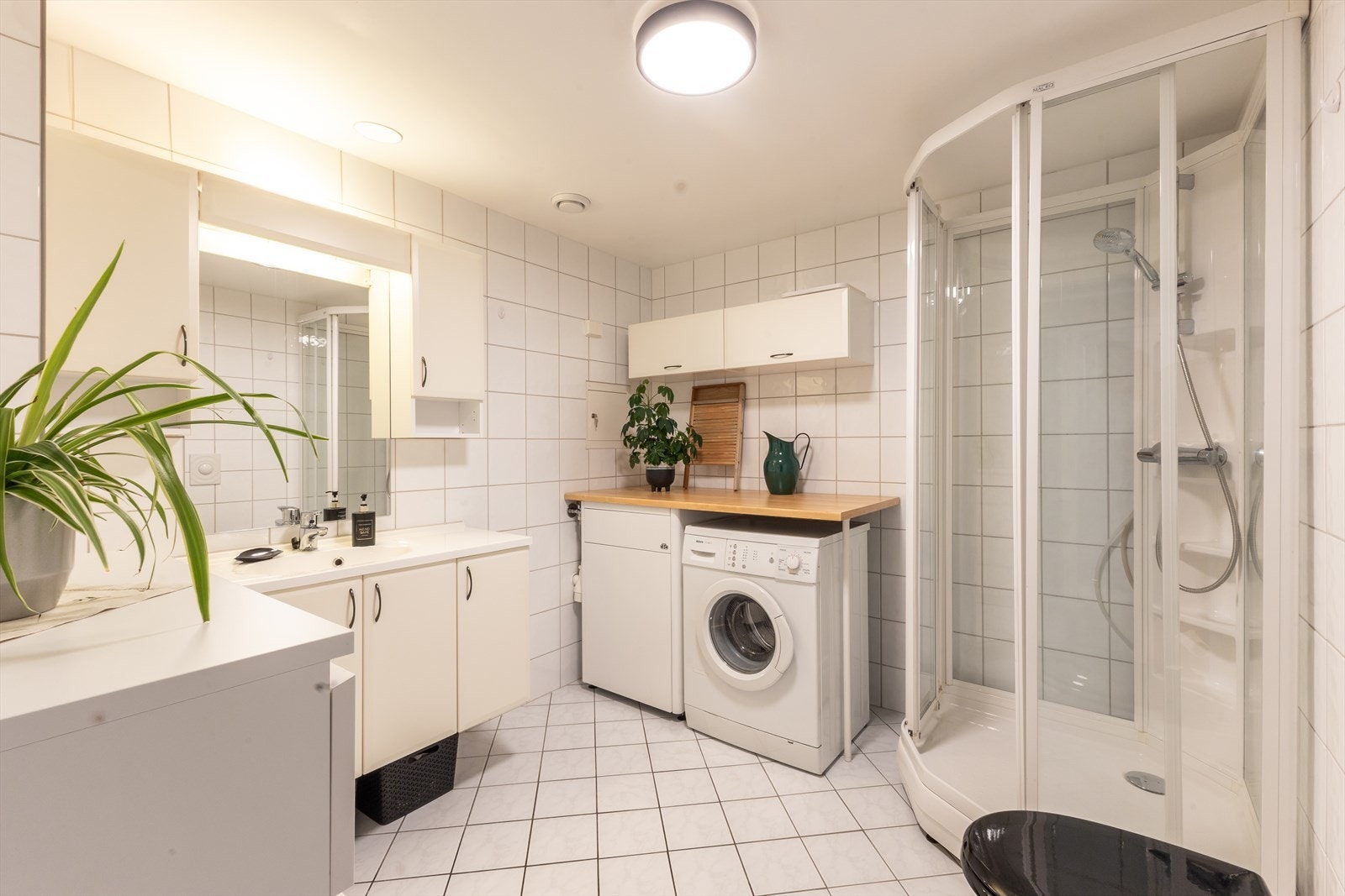 Stort bad/vaskerom som er komplett flislagt. Galleribilde