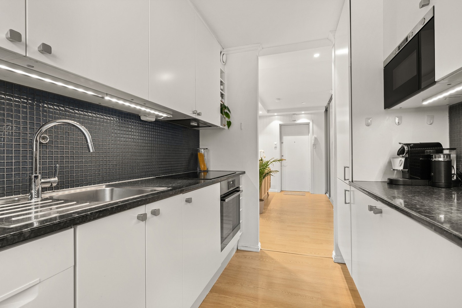 Innredningen har integrerte hvitevarer, benkeplater i laminat og nedfelt kum av stål Galleribilde