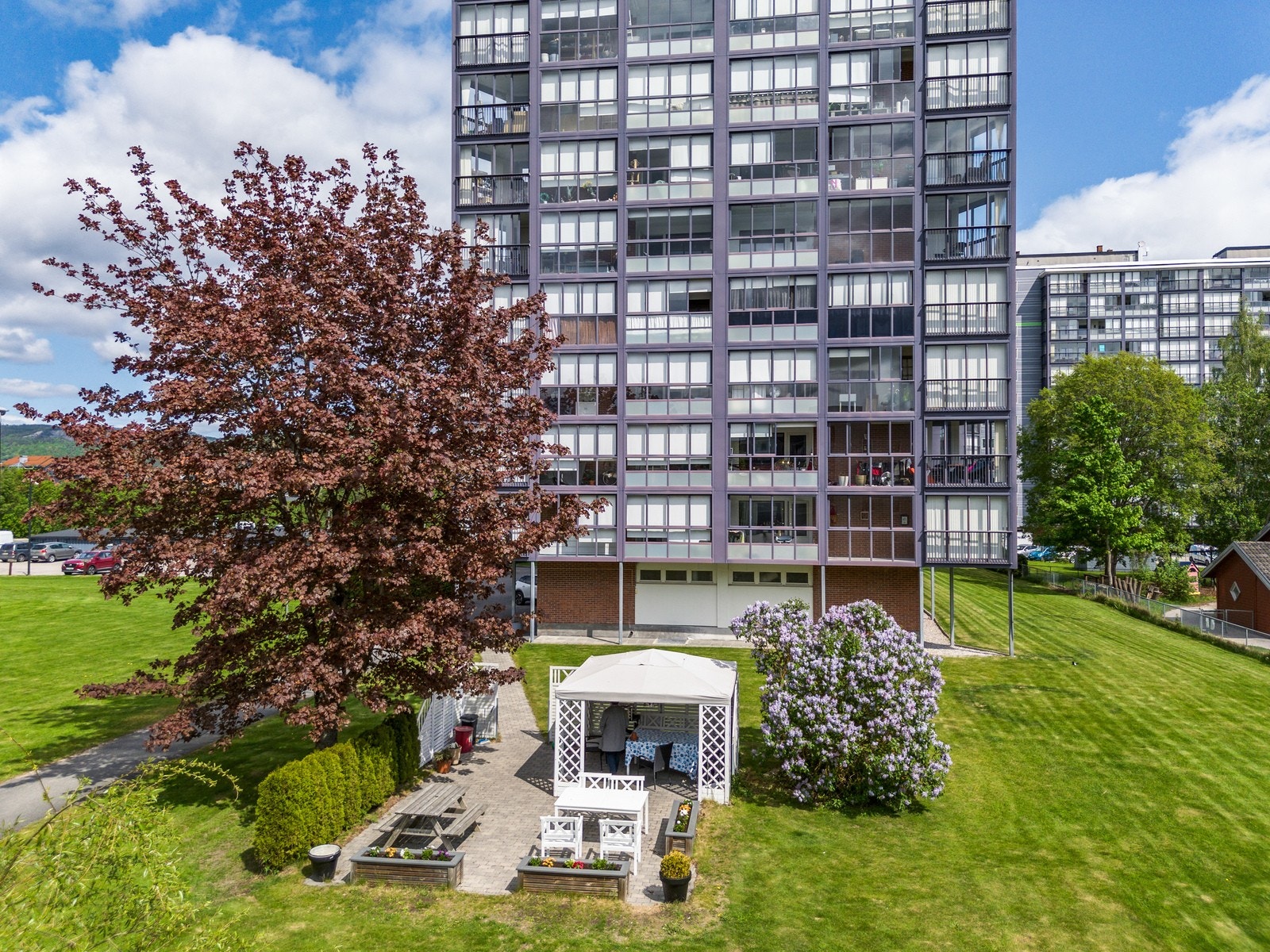 Borettslagets tomt er pent opparbeidet med store grøntarealer med gressplen, beplantning og sittegrupper. Galleribilde