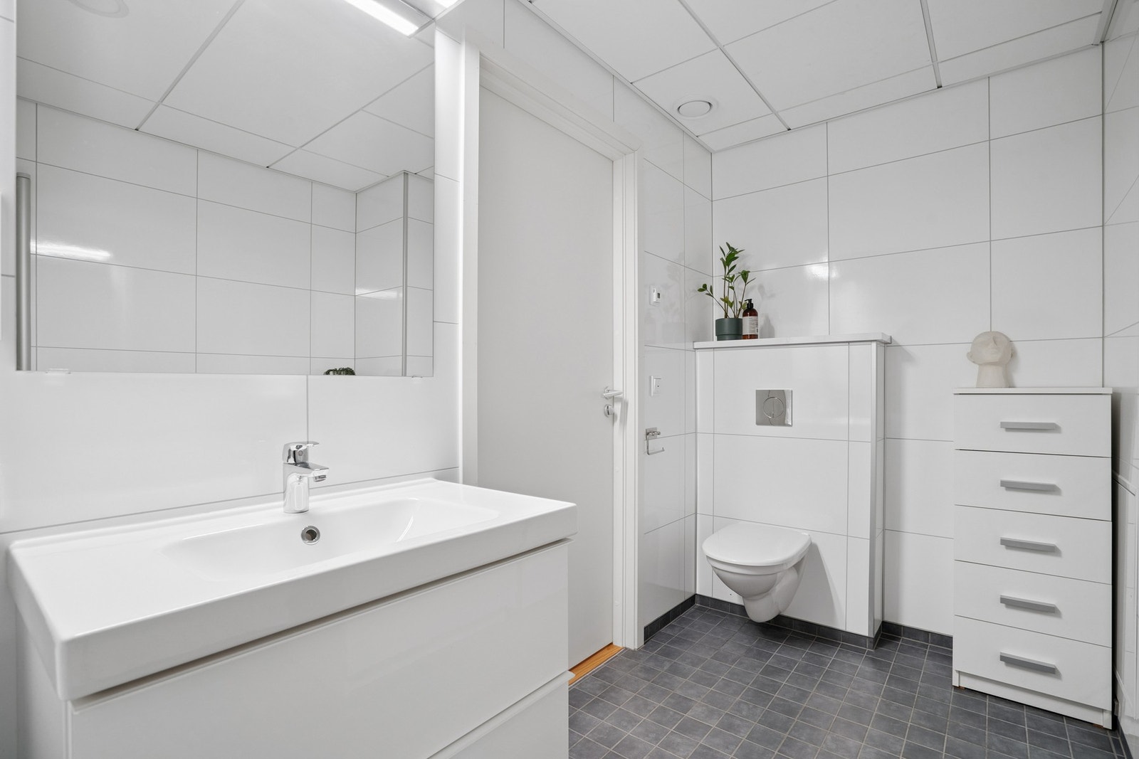 Lyst bad med fliser på gulvet og våtromsplater på vegger. Galleribilde