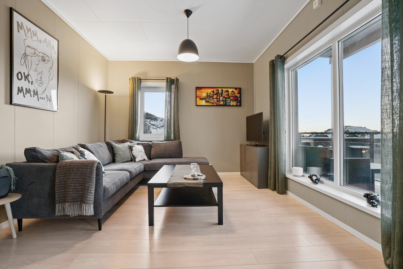 Stuen er i en åpen løsning mot kjøkkenet, med store vindusflater som slipper inn rikelig med dagslys. Galleribilde