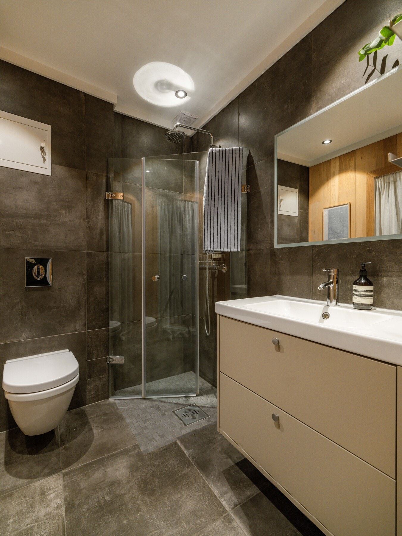 Ellers består det av veggmontert toalett, innfellbare dusjdører og varmekabler i gulv. Galleribilde