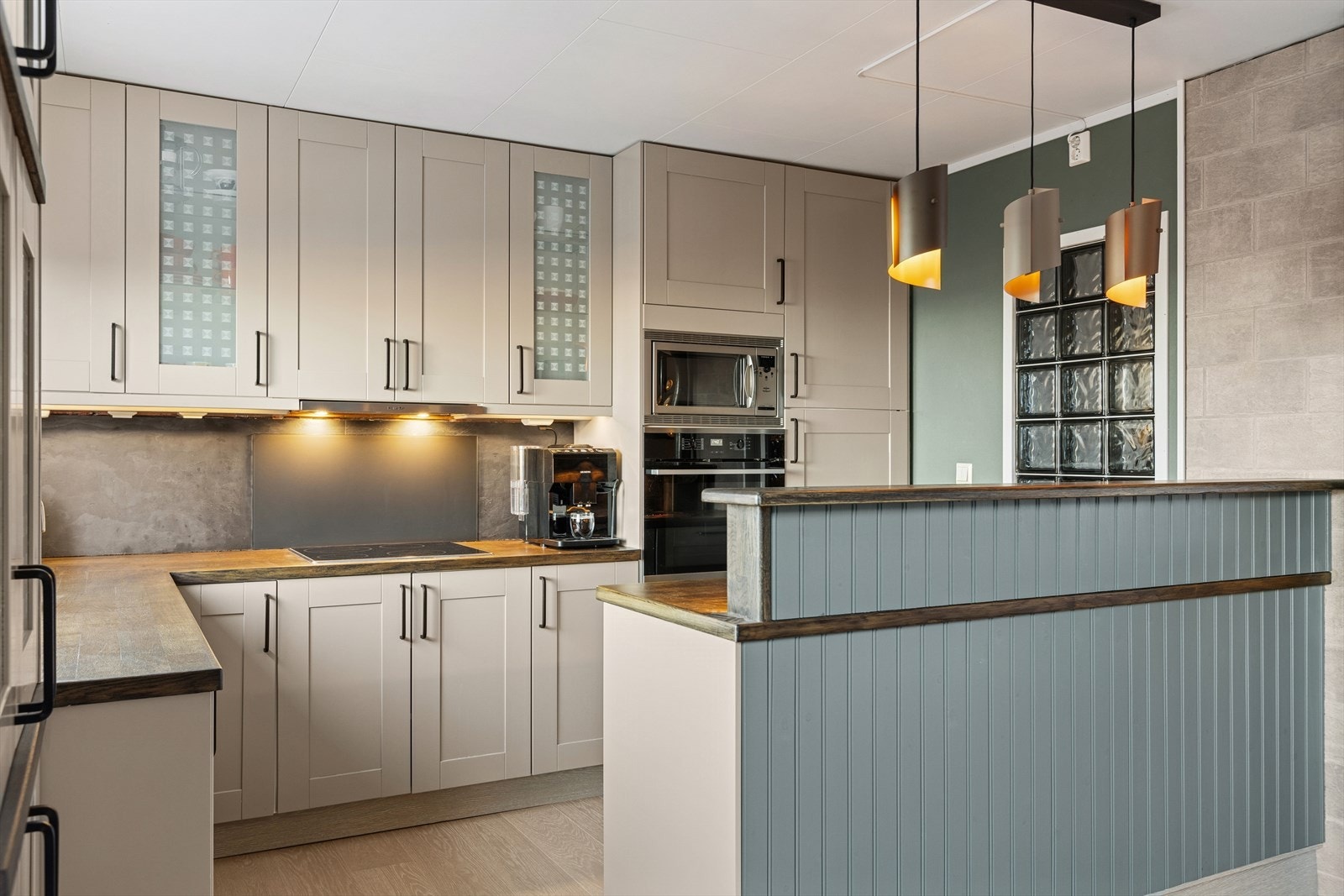 Kjøkkenet tilbyr god benkplass og integrerte hvitevareløsninger Galleribilde