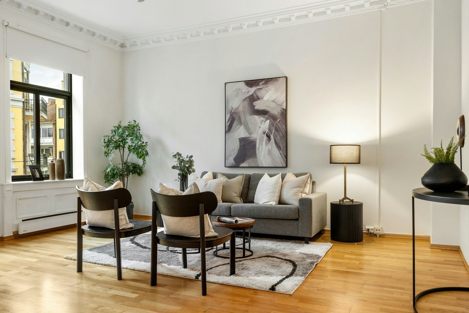 Leiligheten har en romslig og lys stue med to store vinduer som slipper inn rikelig med naturlig lys Galleribilde