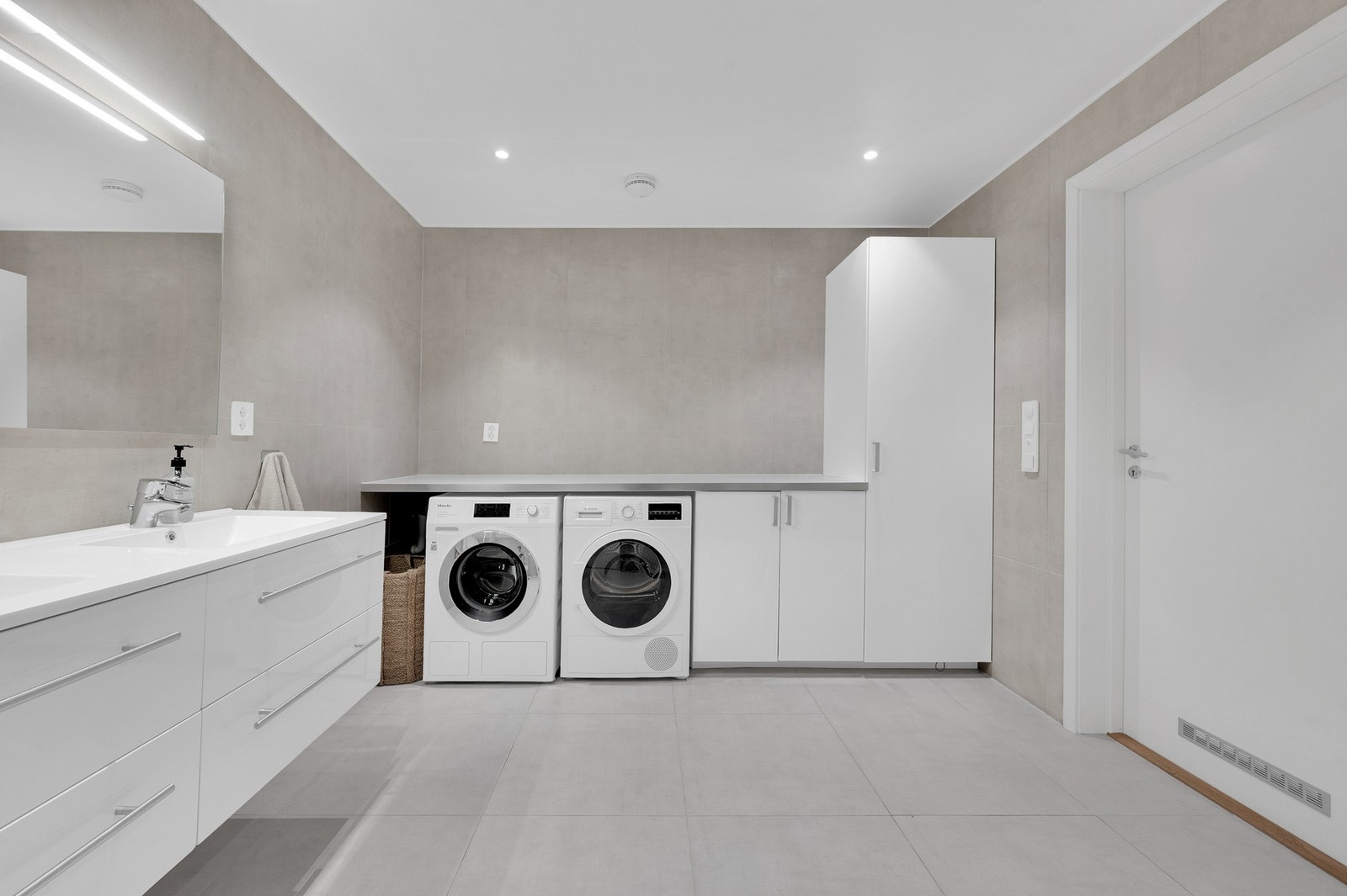 Praktisk innredning med opplegg for både vaskemaskin og tørketrommel. Galleribilde