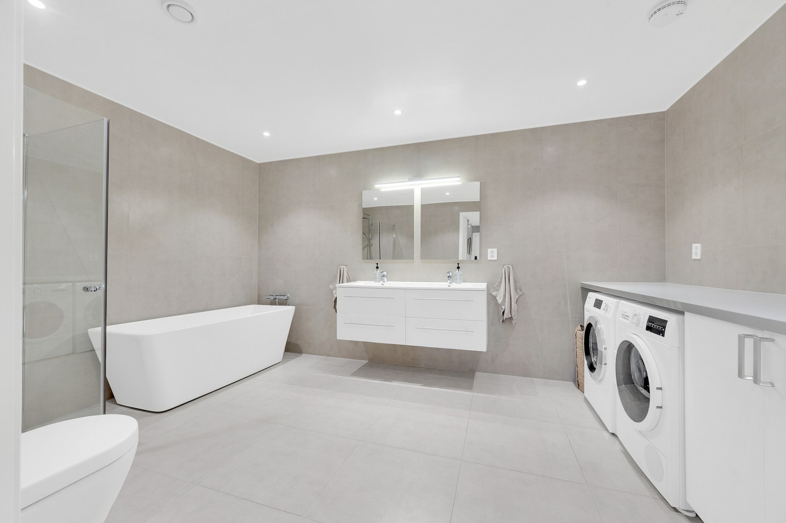 Lekkert flislagt bad med varme i gulv og downlights i tak. Galleribilde