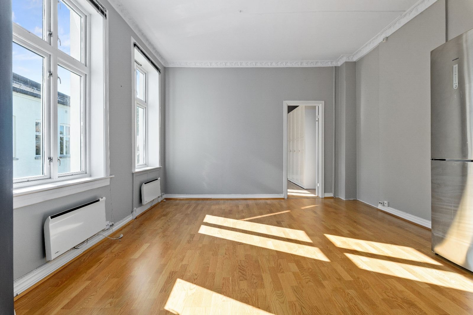 Romslig stue med åpen kjøkkenløsning og stukkatur Galleribilde