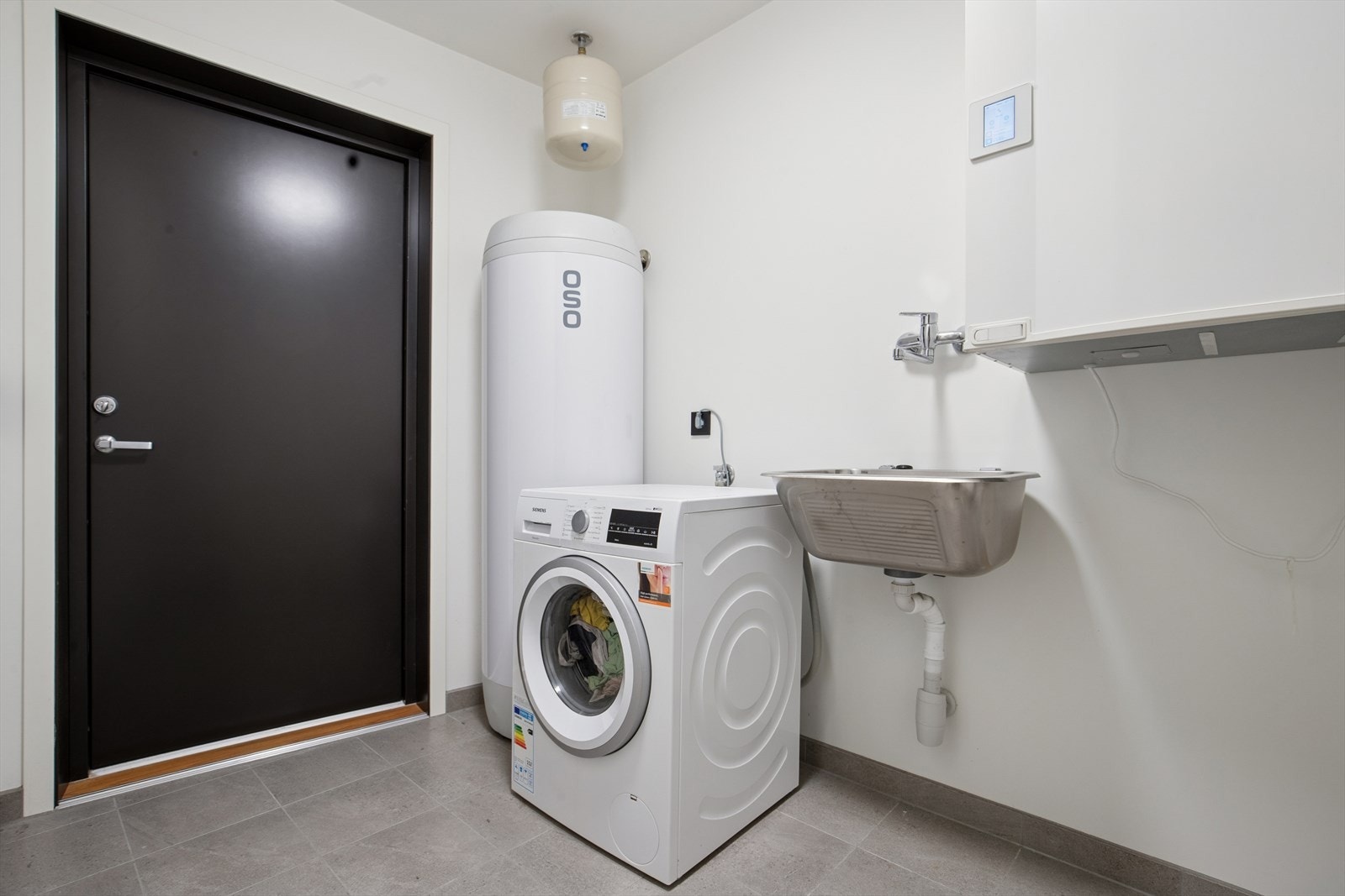 Vaskerommet, som også fungerer som teknisk rom, er fra 2024 og ligger i første etasje. Det har flislagt gulv med elektriske varmekabler, malte plater på veggene og malt tak. Rommet er praktisk utstyrt med en vegghengt oppvaskkum og opplegg for vaskemaskin Galleribilde