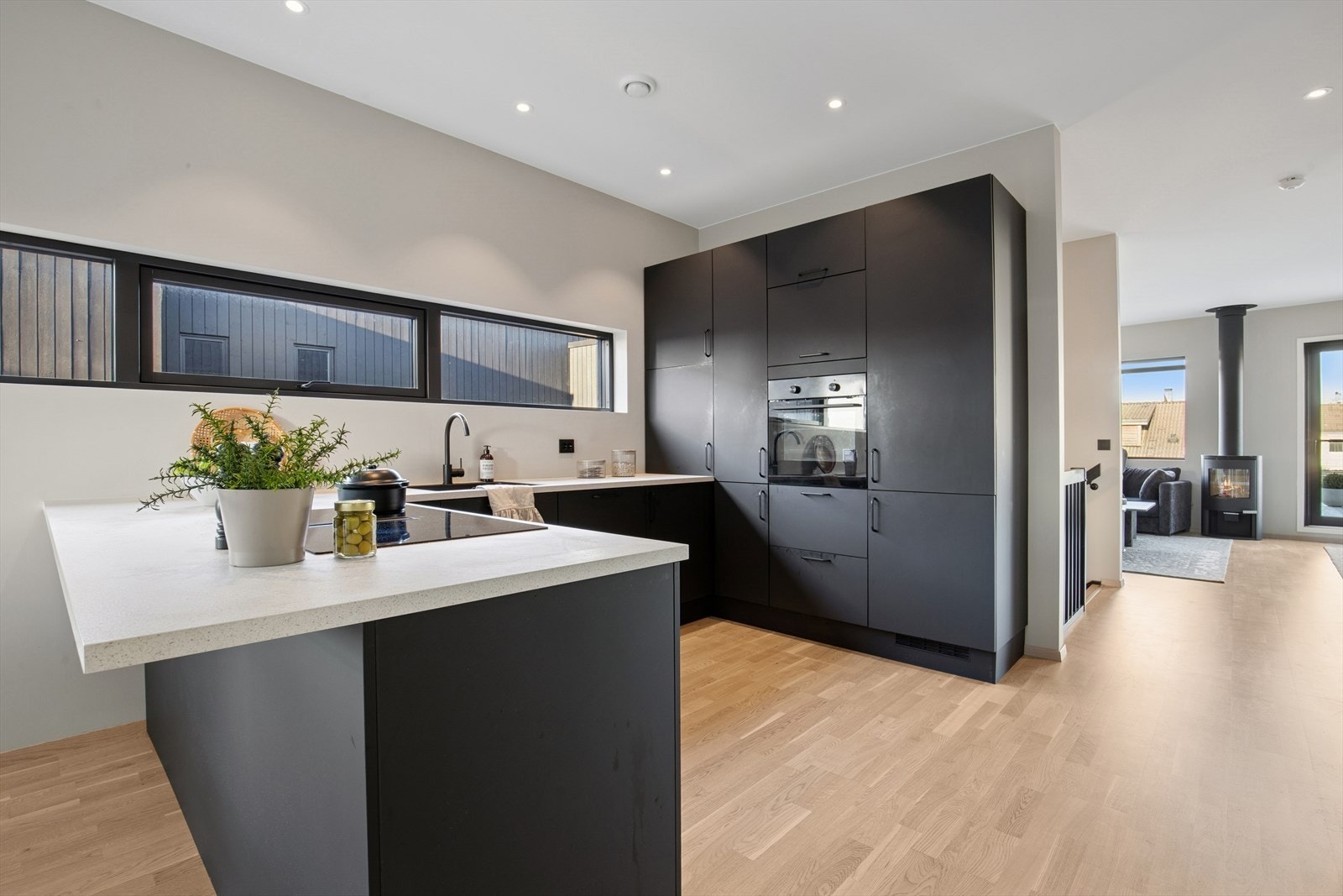 Moderne og tidløst kjøkken fra 2024 med sort innredning med glatte fronter og en benkeplate i laminat. Galleribilde