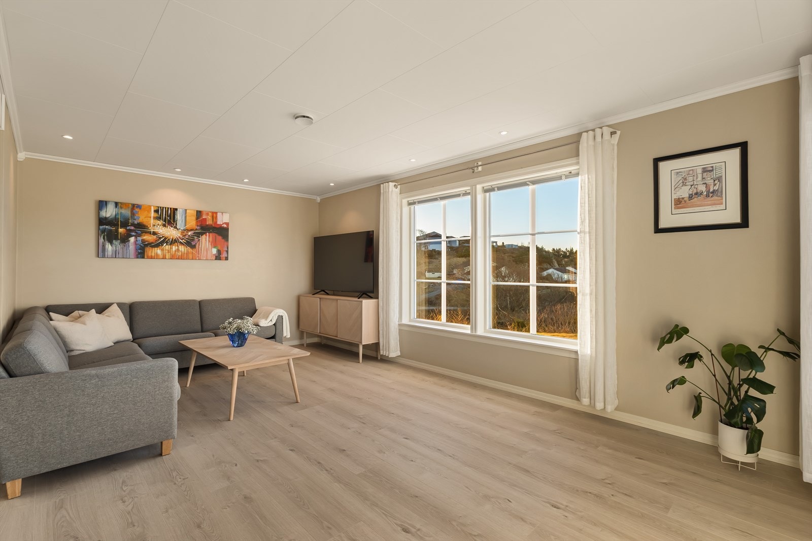 Her er det rikelig med plass til både sofagruppe, stuebord og TV-møblement, samtidig som rommet gir luft og åpenhet. Galleribilde