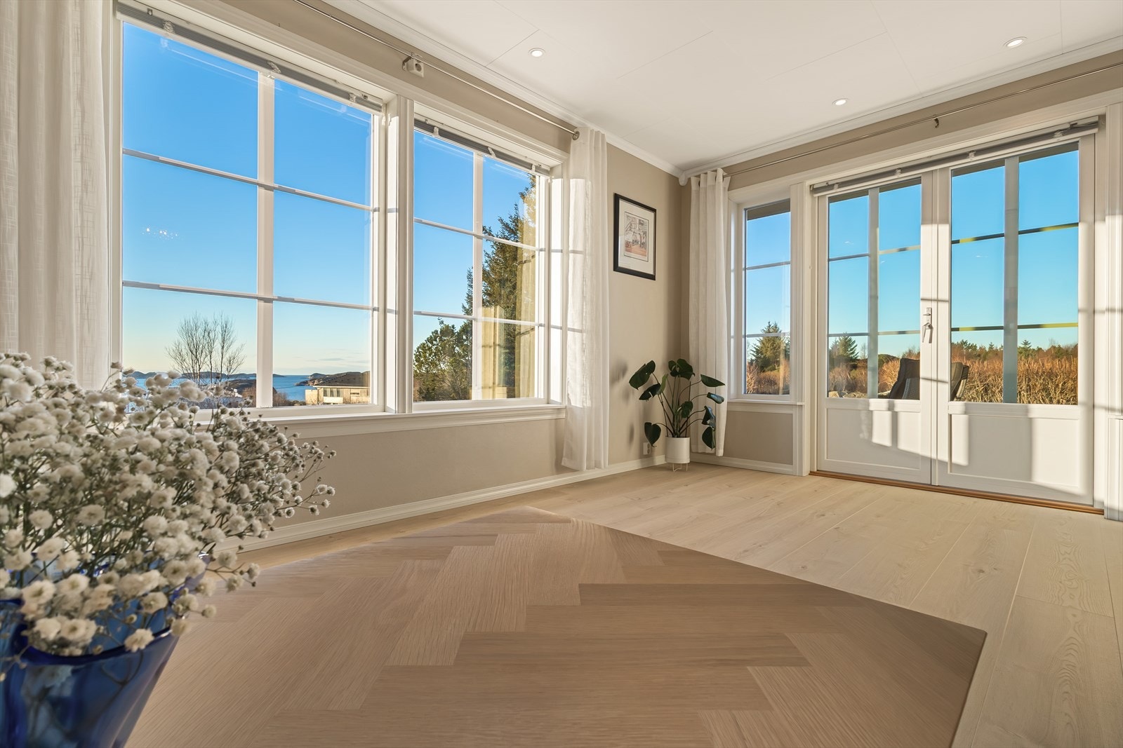 Stuen har store vindusflater som slipper inn rikelig med naturlig lys og gir en fantastisk utsikt mot sjø og fjell. Galleribilde