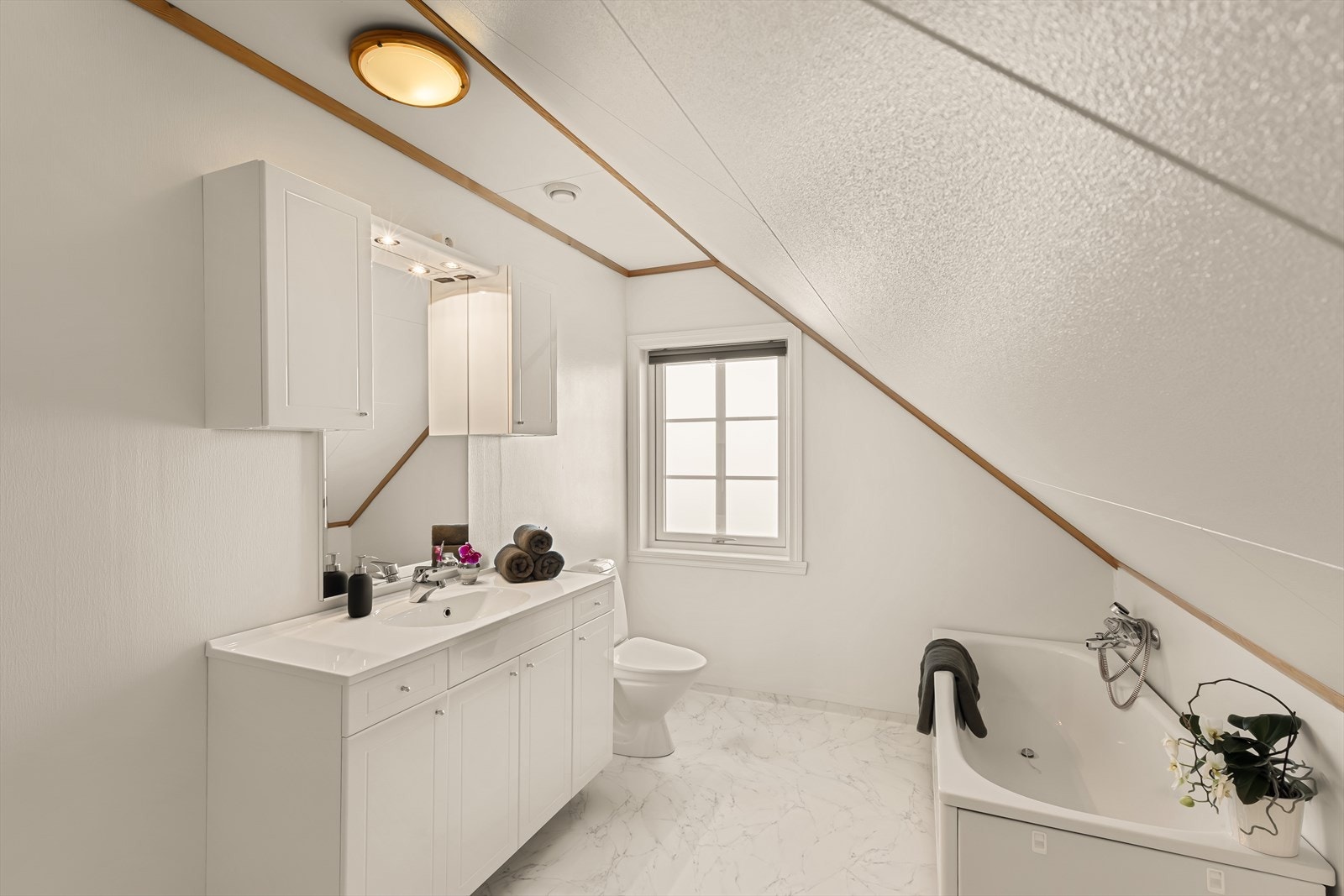 Badet i 2. etasje har våtromsbelegg på gulv med elektriske varmekabler, malt strie på vegger og takplater i himling. Galleribilde