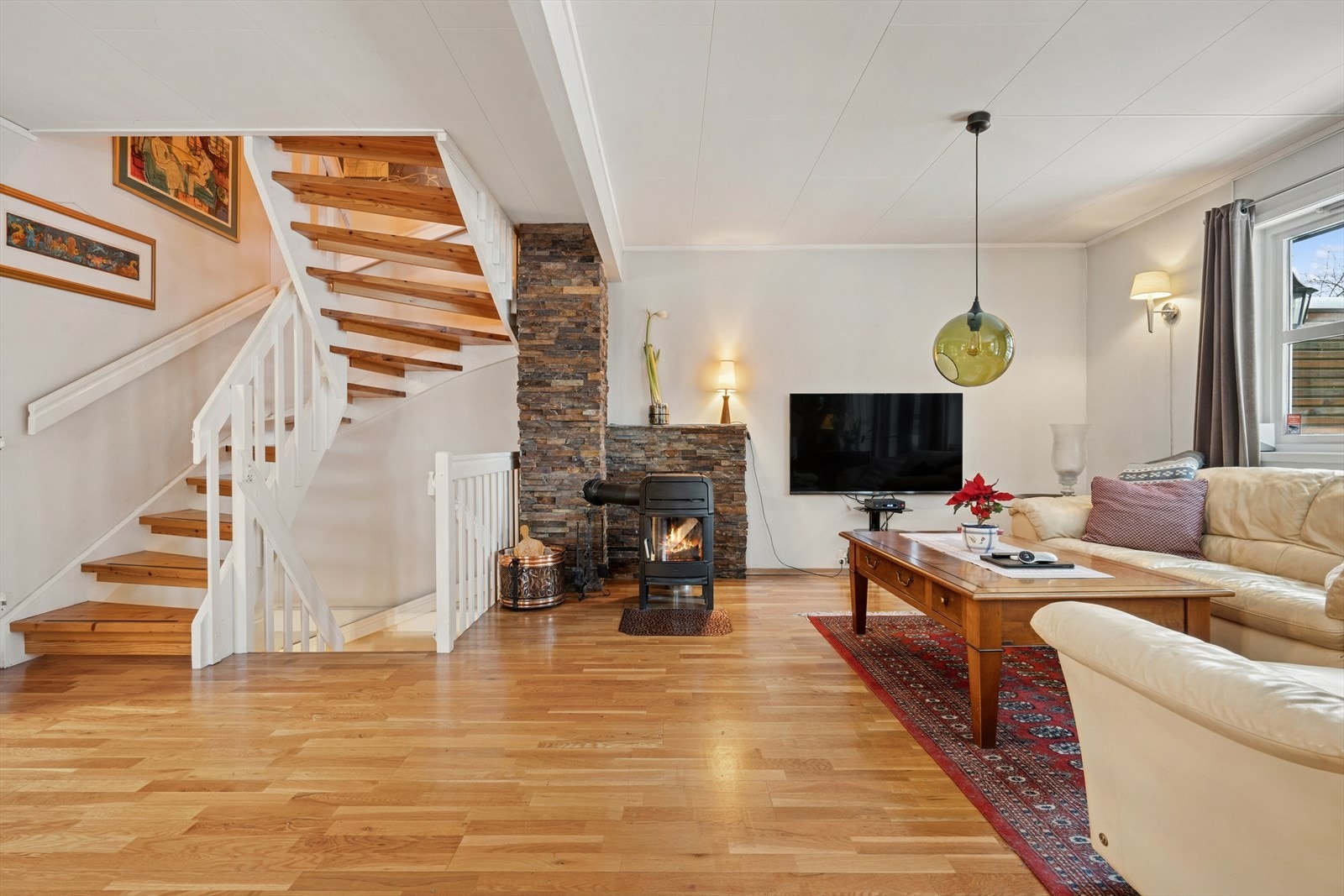 Innbydende stue med en lun og god vedovn (2022). Denne varmer godt på kalde vinterdager Galleribilde