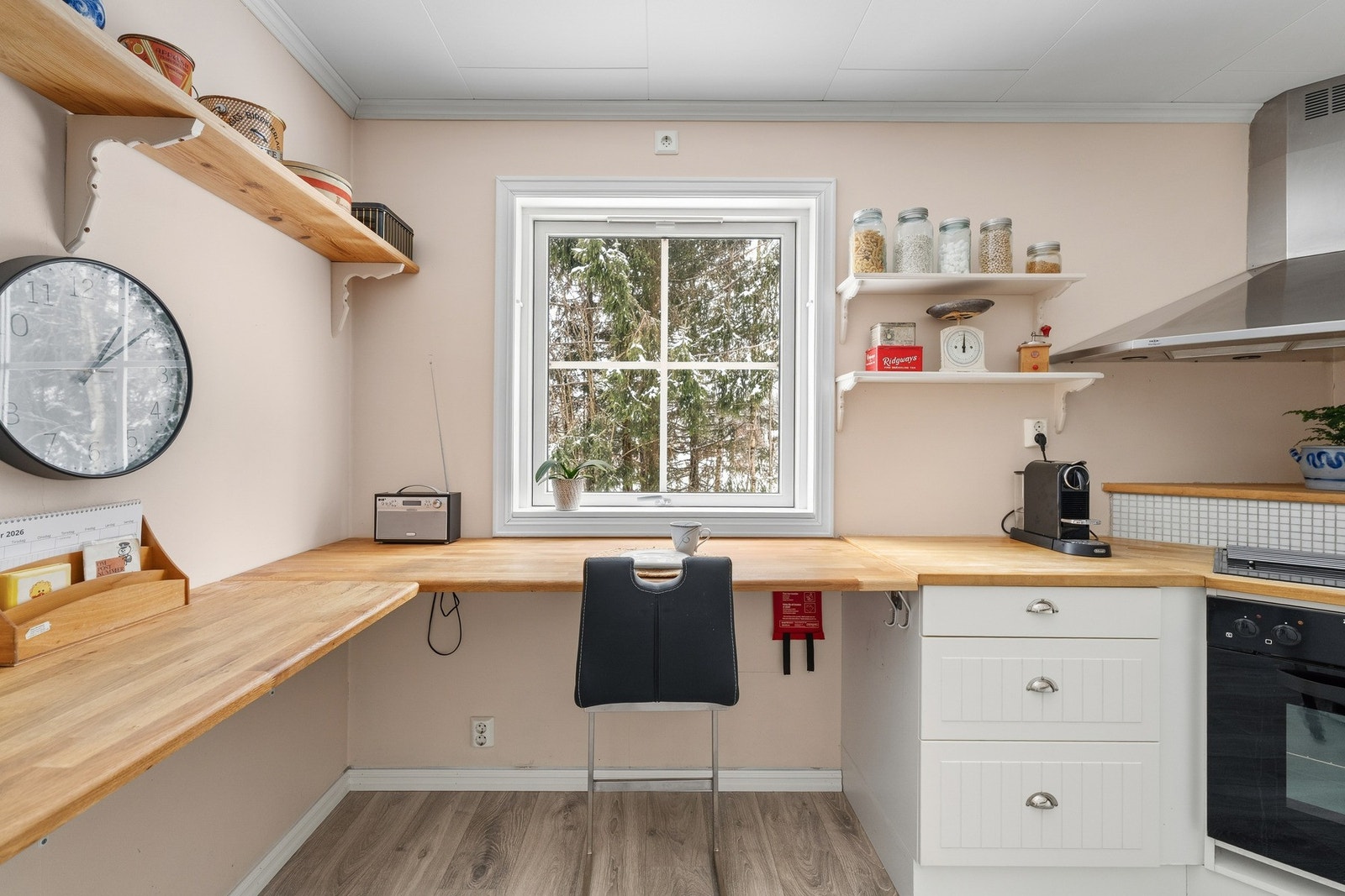 Moderne mosaikkfliser mellom over- og underskap, samt over kokesonen. Hvitevarer som medfølger: integrert komfyr, platetopp, halvintegrert oppvaskmaskin og kombinert kjøl/frys. Galleribilde