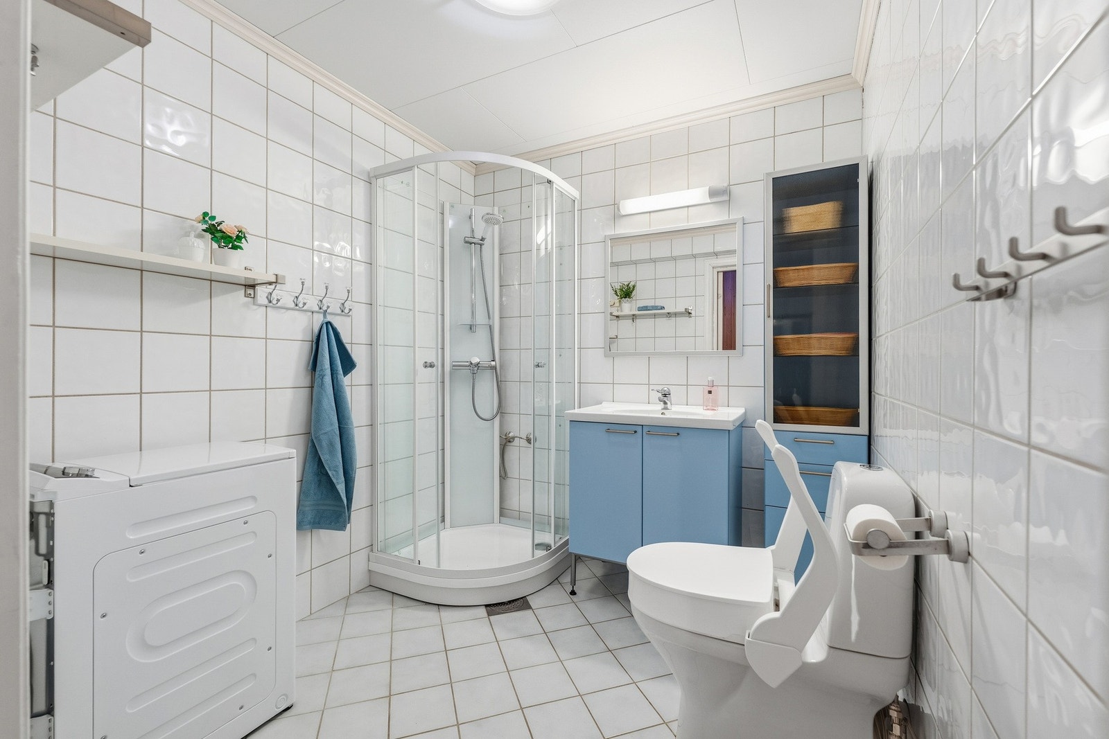 Stort flislagt hovedbad i boligens 1. etasje fra byggeår. Innredningen består av servantskap, speil, samt tilhørende høyskap. Galleribilde