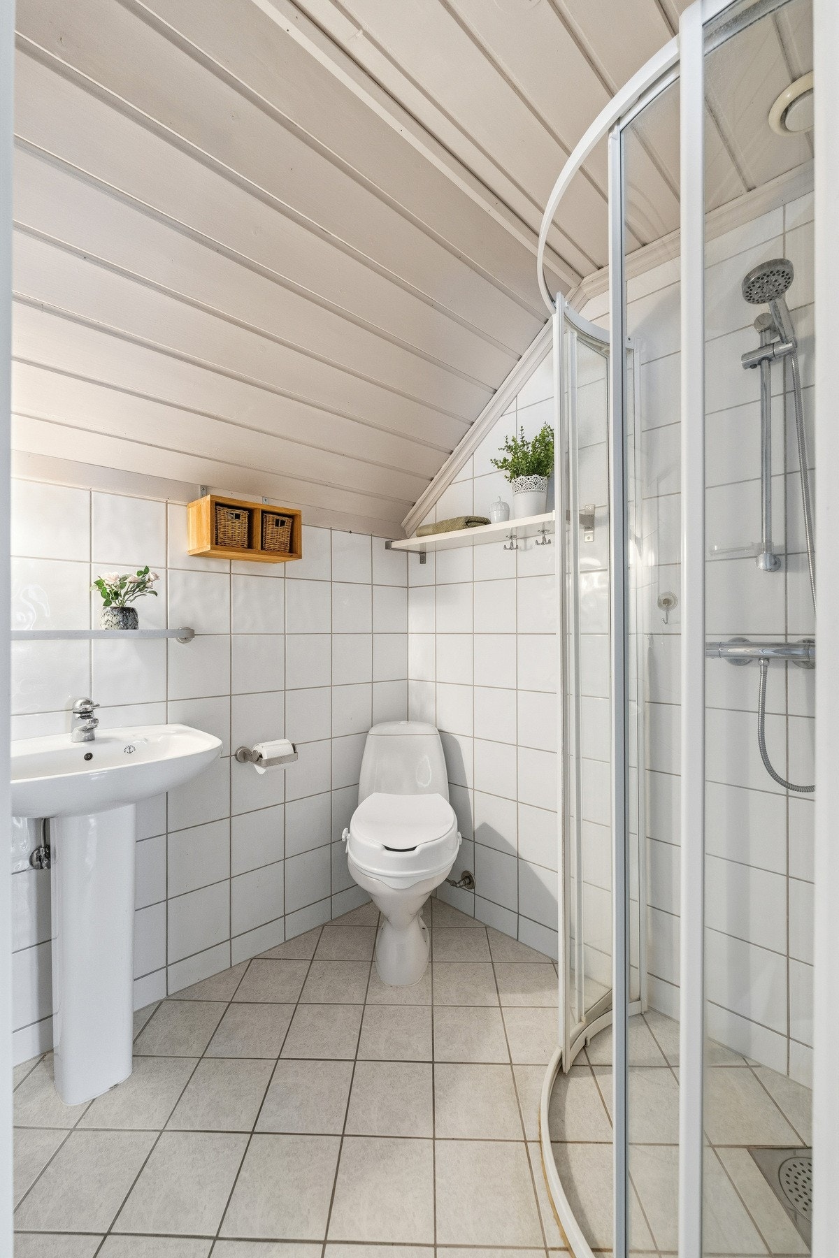 Innredningen består av enkel søyleservant, toalett, samt dusjhjørne med glassdører. Det er lagt varmekabler i gulv. Galleribilde