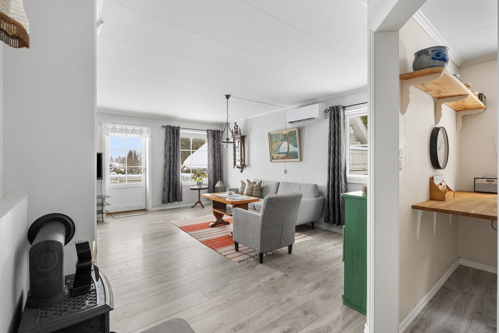 Innbydende stue med lyse, tidsriktige farger og gråpigmentert laminatgulv (nytt i 2020) med behagelig gulvvarme, som strekker seg sømløst inn i kjøkkenet. Galleribilde