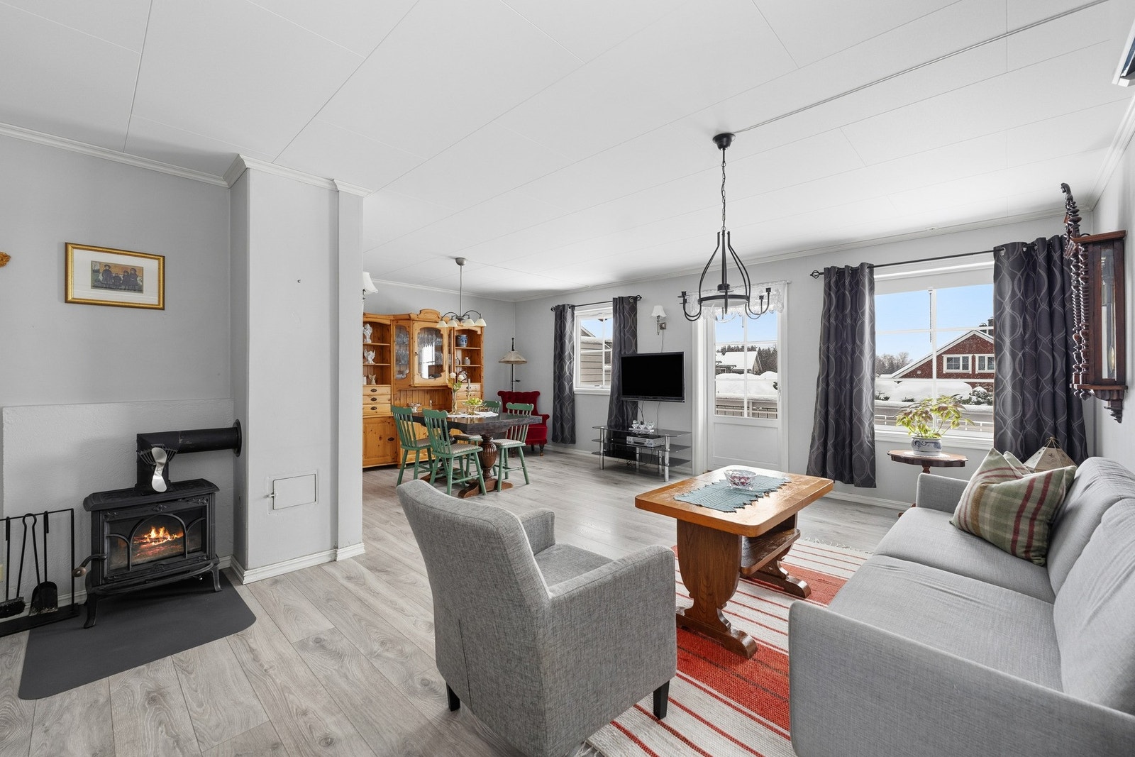 Midt i rommet står en sjarmerende peisovn, og i tillegg er det montert en luft-til-luft varmepumpe på vegg (ny 2025) som gir jevn temperatur året rundt. Galleribilde