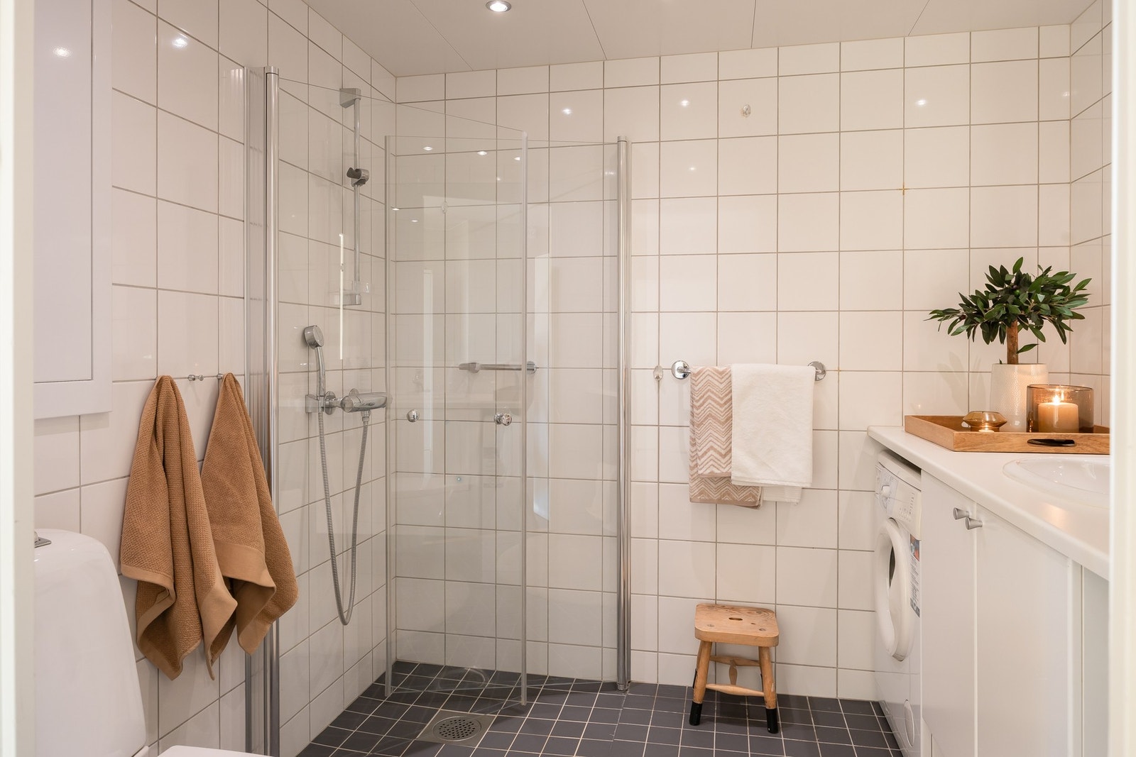 Rommet er innredet med praktisk dusjhjørne, vegghengt toalett, rikelig med lagringsplass og opplegg for vaskemaskin. Galleribilde