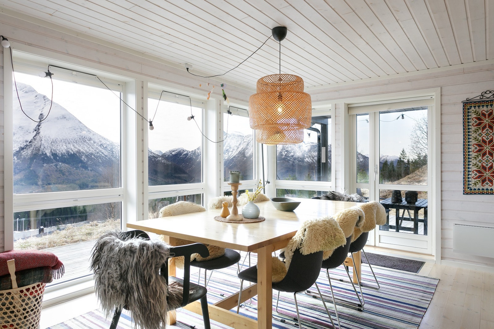 Lys og innbydende spisestue med storslått panoramautsikt over majestetiske fjell, perfekt for å nyte naturens skjønnhet året rundt. Galleribilde