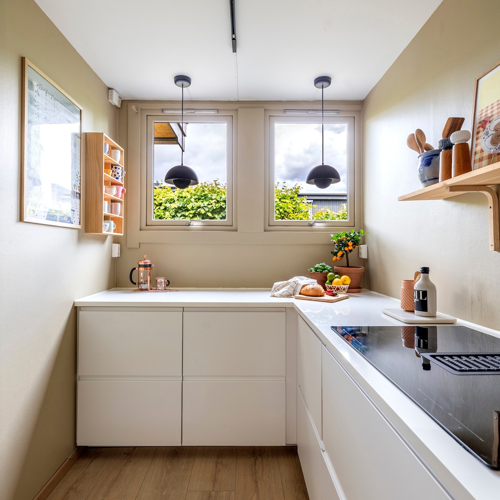 Kjøkkenet har rikelig med oppbevaringsmuligheter og arbeidsplass, mens en hylle på vegg over kjøkkenbenken gir et stilfullt preg. Galleribilde