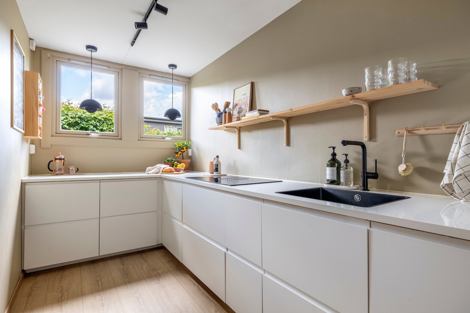 Det funksjonelle L-formede designet utnytter plassen godt, og den romslige benkeplassen gjør matlagingen både enkel og effektiv. Galleribilde