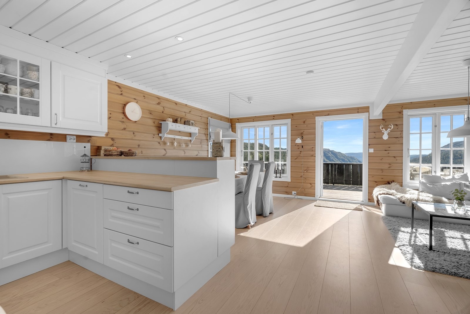 Åpen stue/kjøkken med store vindusflater som gir godt med naturlig lys Galleribilde