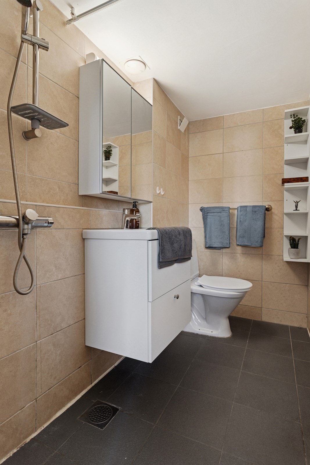 Flislagt bad oppusset i 2013 og har WC, åpen dusjplass, servant og varmekabler i gulv. Ny servant og blandebatteri(2024) Galleribilde