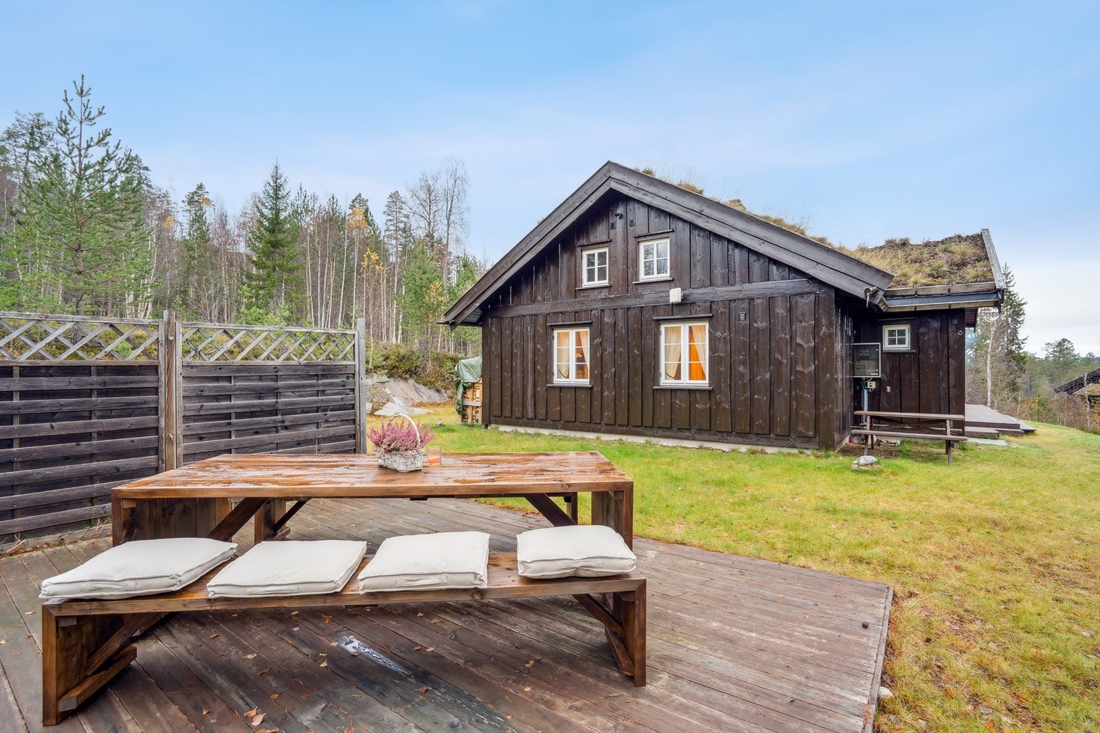 Pen uteområde med langbord og benk på platting. Galleribilde