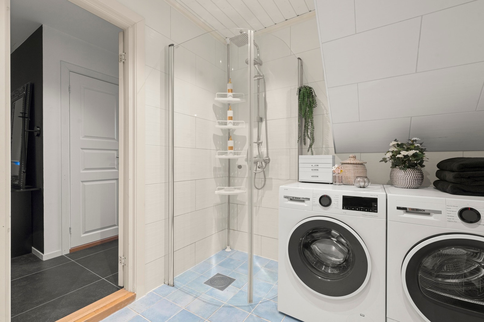 Badet er utstyrt med gulvvarme, downlights, vegghengt toalett, dusjnisje, servant og opplegg for vaskemaskin Galleribilde