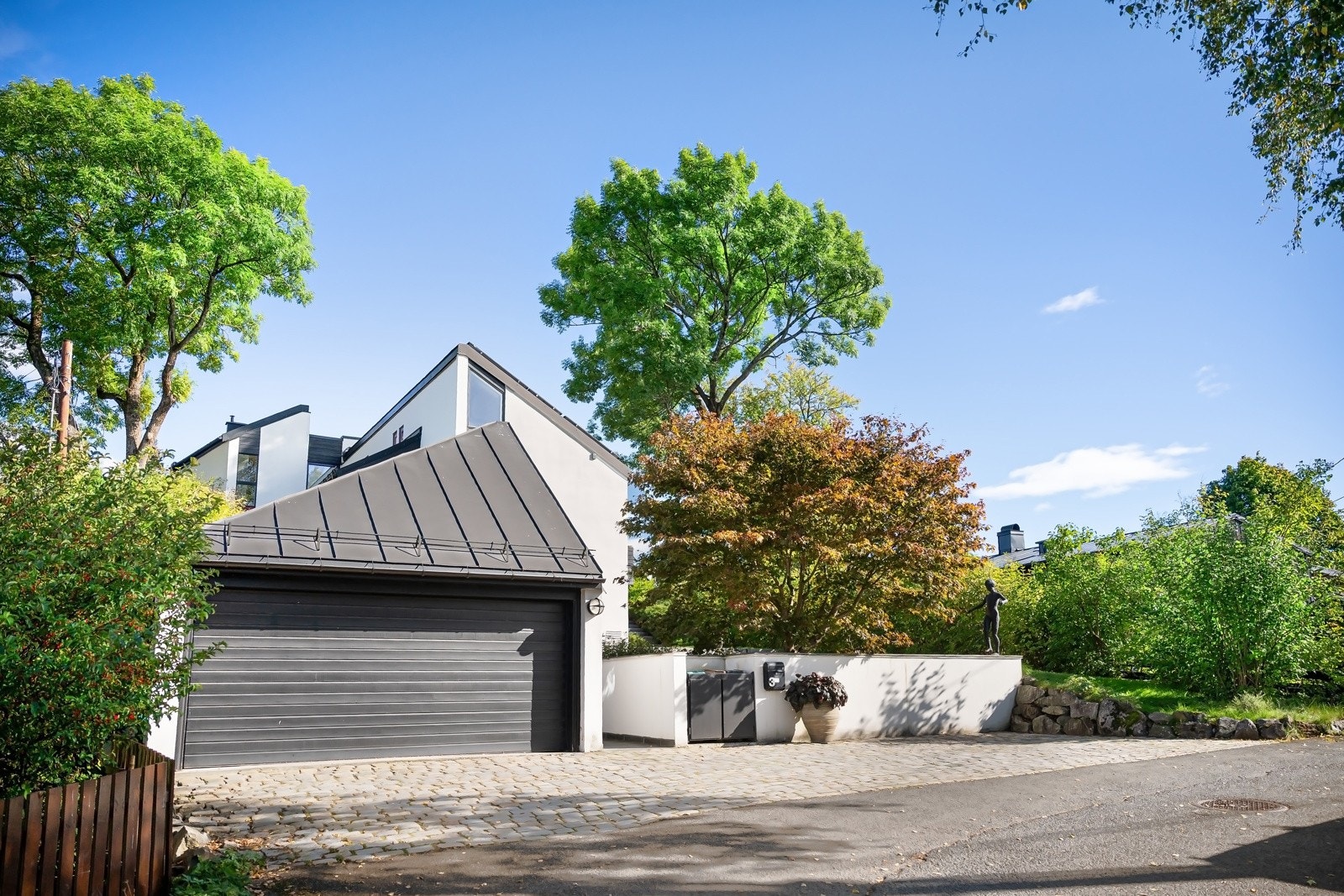 Enkel parkering i dobbelgarasje med elbillader, i tillegg på romslig gårdsplass belagt med ferdig patinerte brostein. Galleribilde