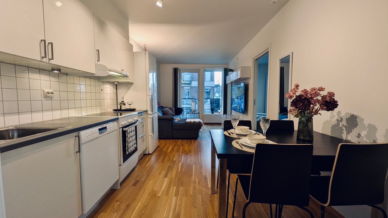 Stue/kjøkkenløsning med store vindusflater som slipper inn mye naturlig lys Galleribilde