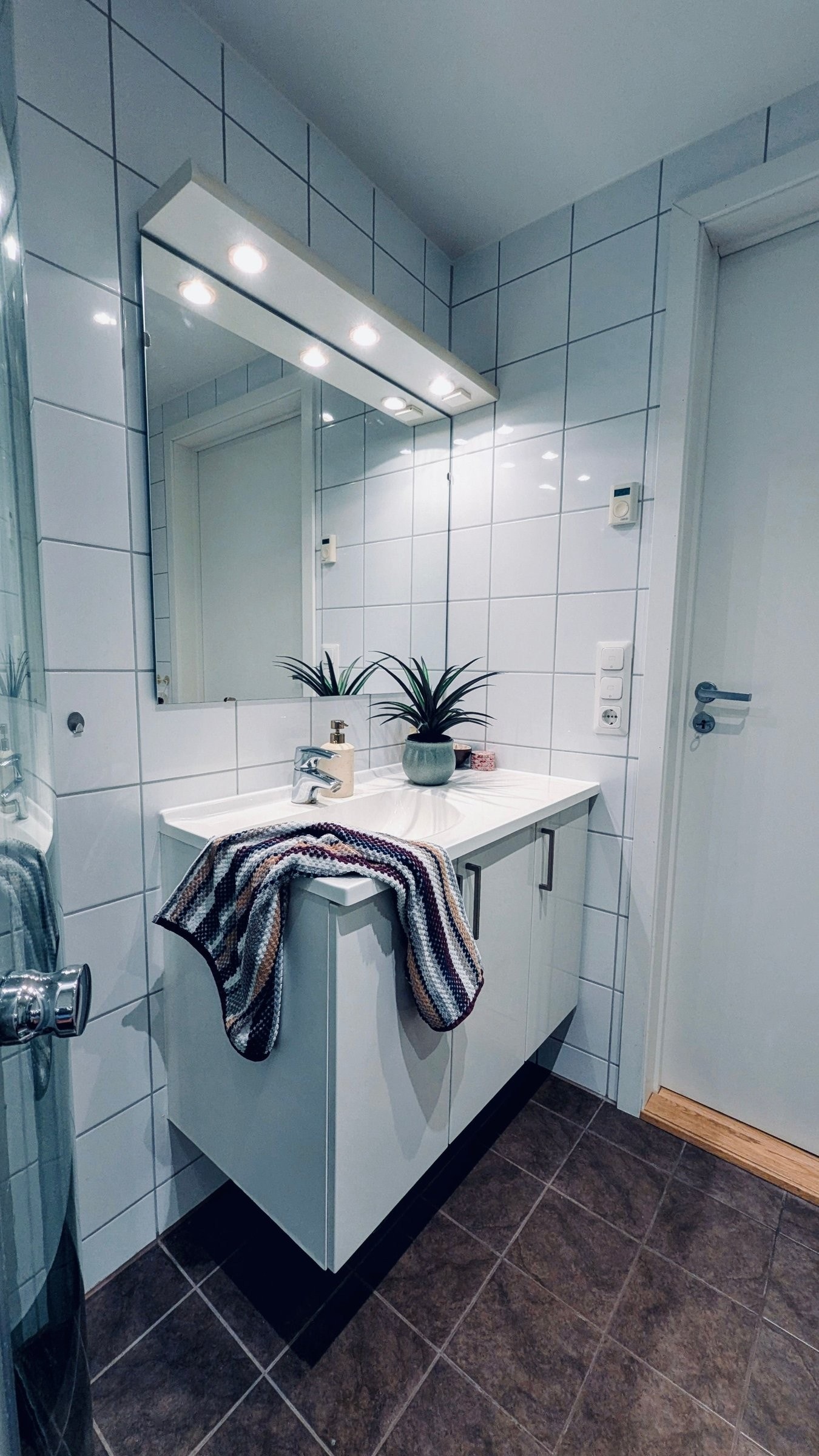Badet er holdt i en nøytral og smakfull stil, med fliser på både gulv og vegger samt en moderne, tidløs innredning Galleribilde