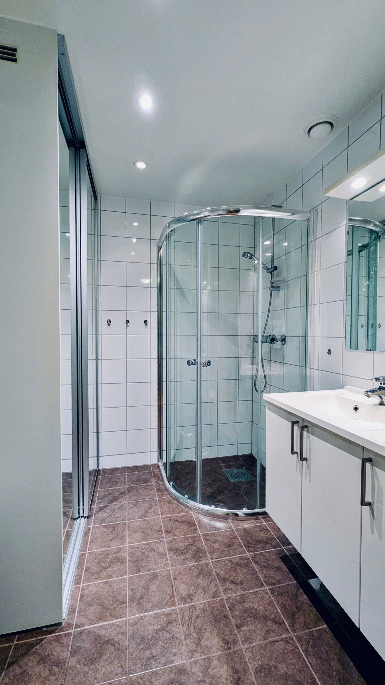 Bak store speilflater skjuler det seg en praktisk vaskeromsløsning med plass til både vaskemaskin, tørketrommel og oppbevaring Galleribilde