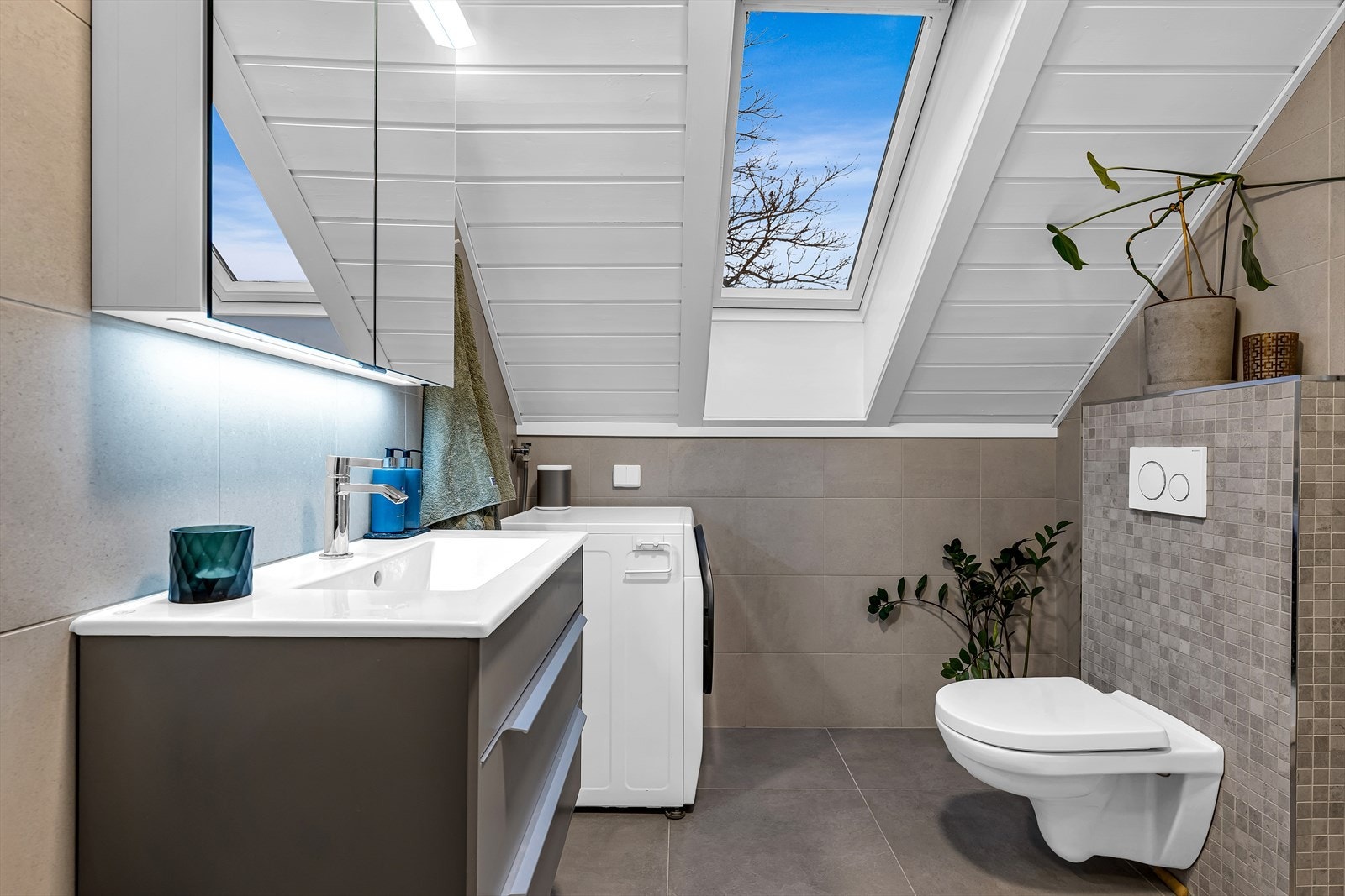 Baderom pusset opp i 2020, innredet med flislagt gulv med fliser, og flislagte vegger. Vegghengt servantskap i slett utførelse, med innvendig hyller og speil. Galleribilde