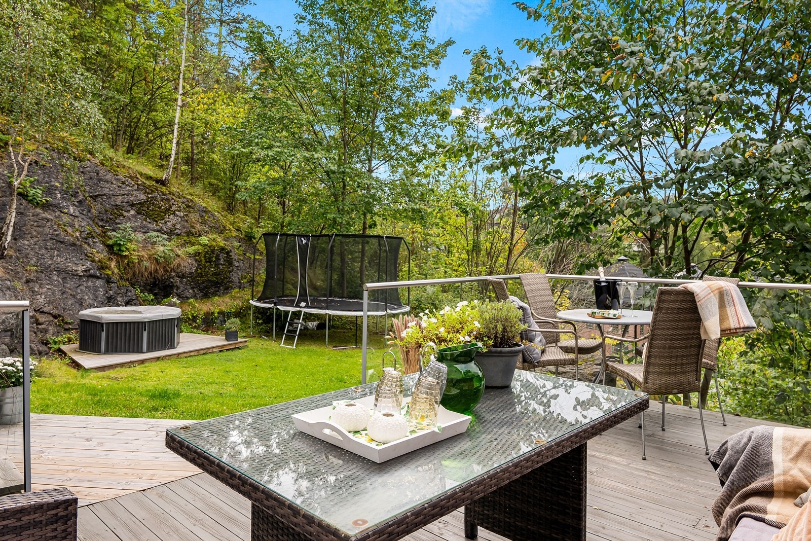 Frodige omgivelser. Hagen her ligger øvrig på naboens eiendom med gnr. 50, bnr. 2, og eies ikke av sameiet. Tomtegrensen går parallelt med terrassen og husveggen. Galleribilde