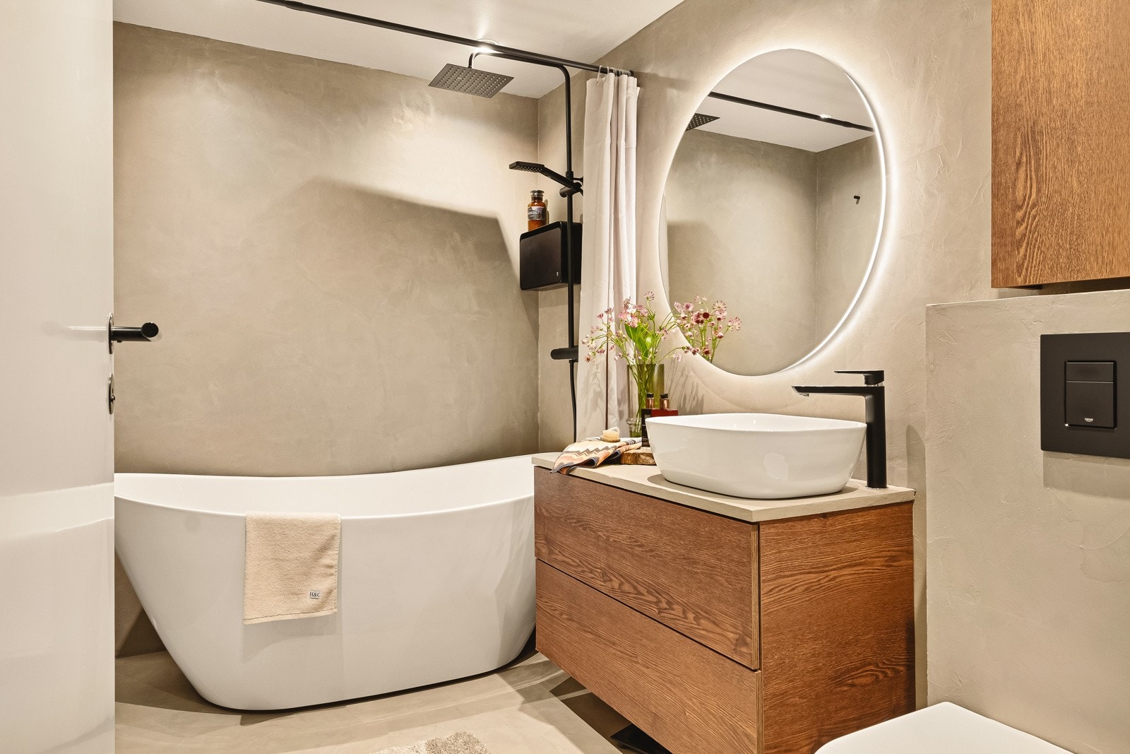 - Moderne baderomsinnredning, vegghengt toalett, badekar med svart fossefall-dusj og flott rundt speil over baderomsinnredningen med integrert lys - Galleribilde