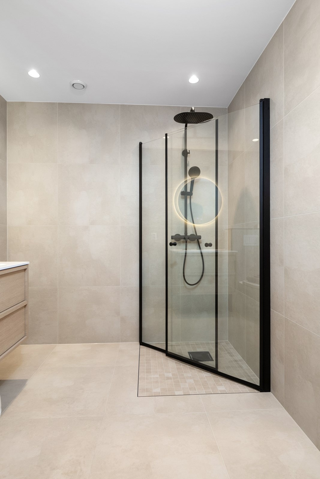 Badet har downlights i taket og sorte detaljer som gir et tidsriktig uttrykk. Galleribilde