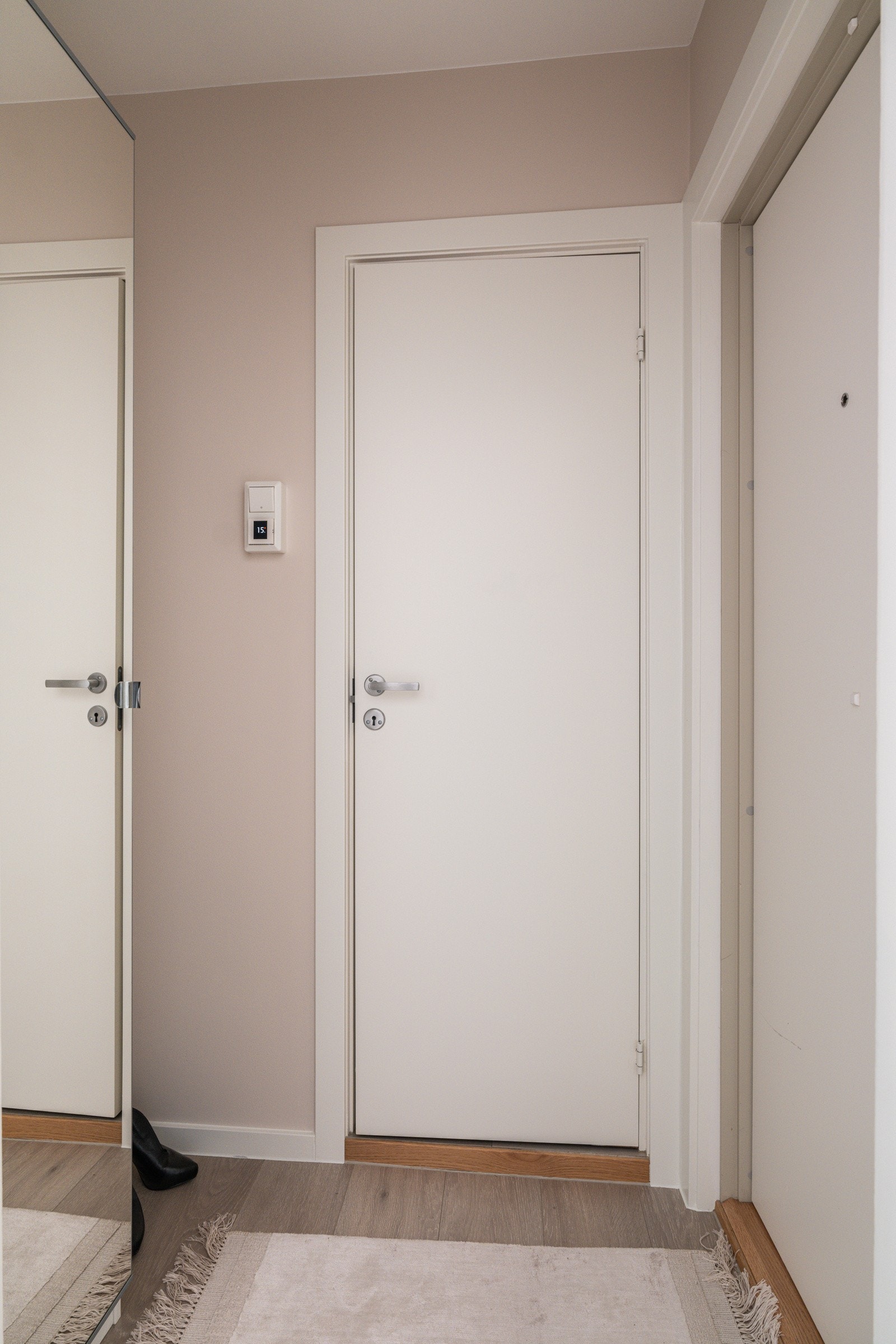 Når du entrer leiligheten, kommer du inn i en innbydende og praktisk entré. God standard med moderne enstavs laminat fra 2020 på gulv og glatte overflater malt i en innbydende farge. Galleribilde