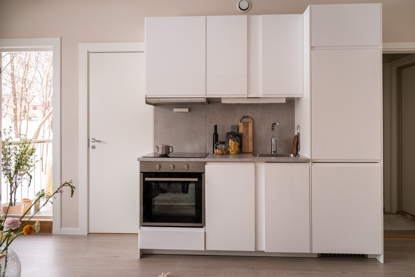 Lys og moderne kjøkkeninnredning fra Ikea som var ny i 2020. Innredningen har hvite glatte fronter og laminert benkeplate med nedfelt oppvaskkum. Både fint og praktisk med flotte fliser i benkeryggen og belysning under overskapene. Galleribilde