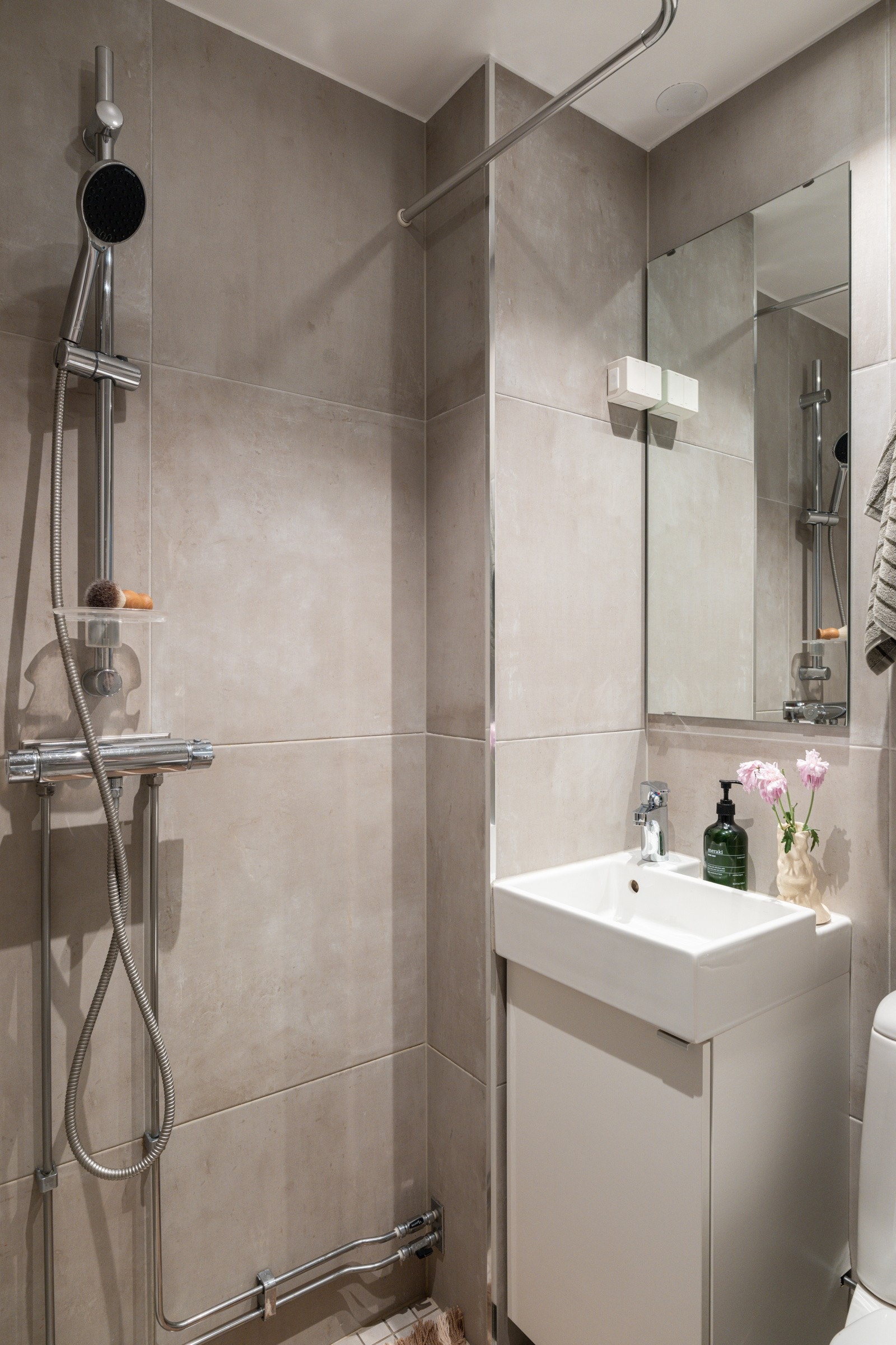 Baderommet er utstyrt med servantskap med speil over, dusjhjørne med forheng og gulvstående toalett. Galleribilde