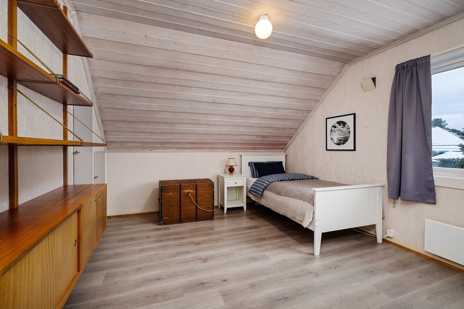 Et av de tre soverommene i etasjen, med god plass og skråtak med panel. Galleribilde