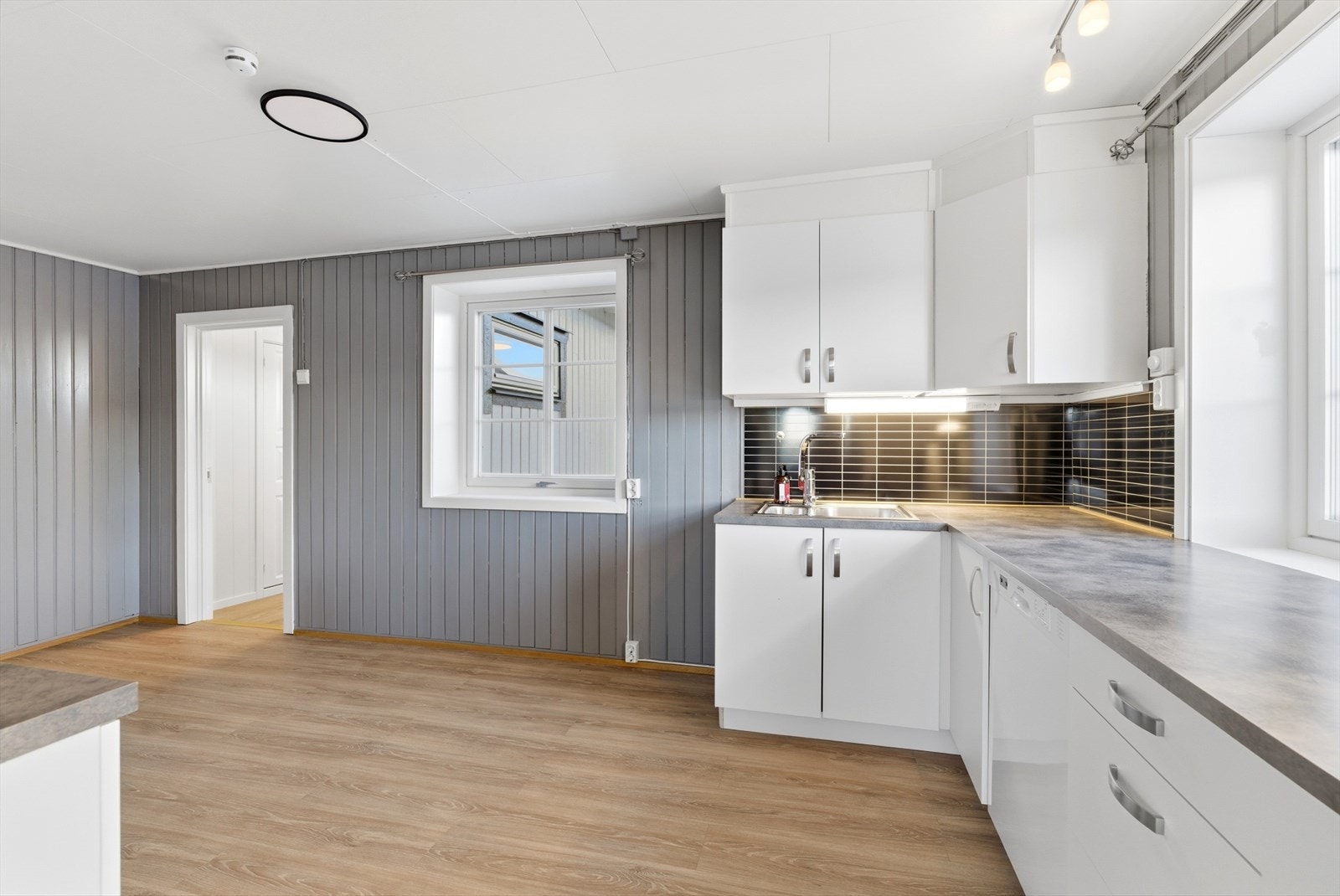 Hvite slette fronter og benkeplate av typen laminat. Galleribilde