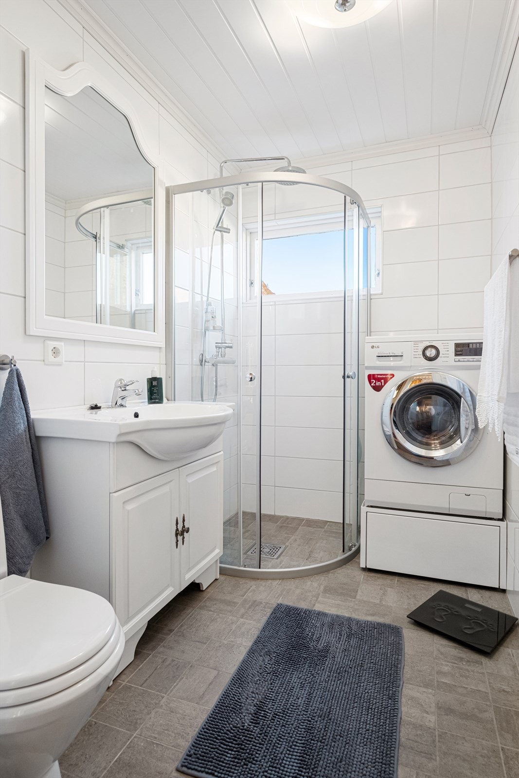 Pent bad med fliser på gulv og vegg. Opplegg for vaskemaskin. Galleribilde