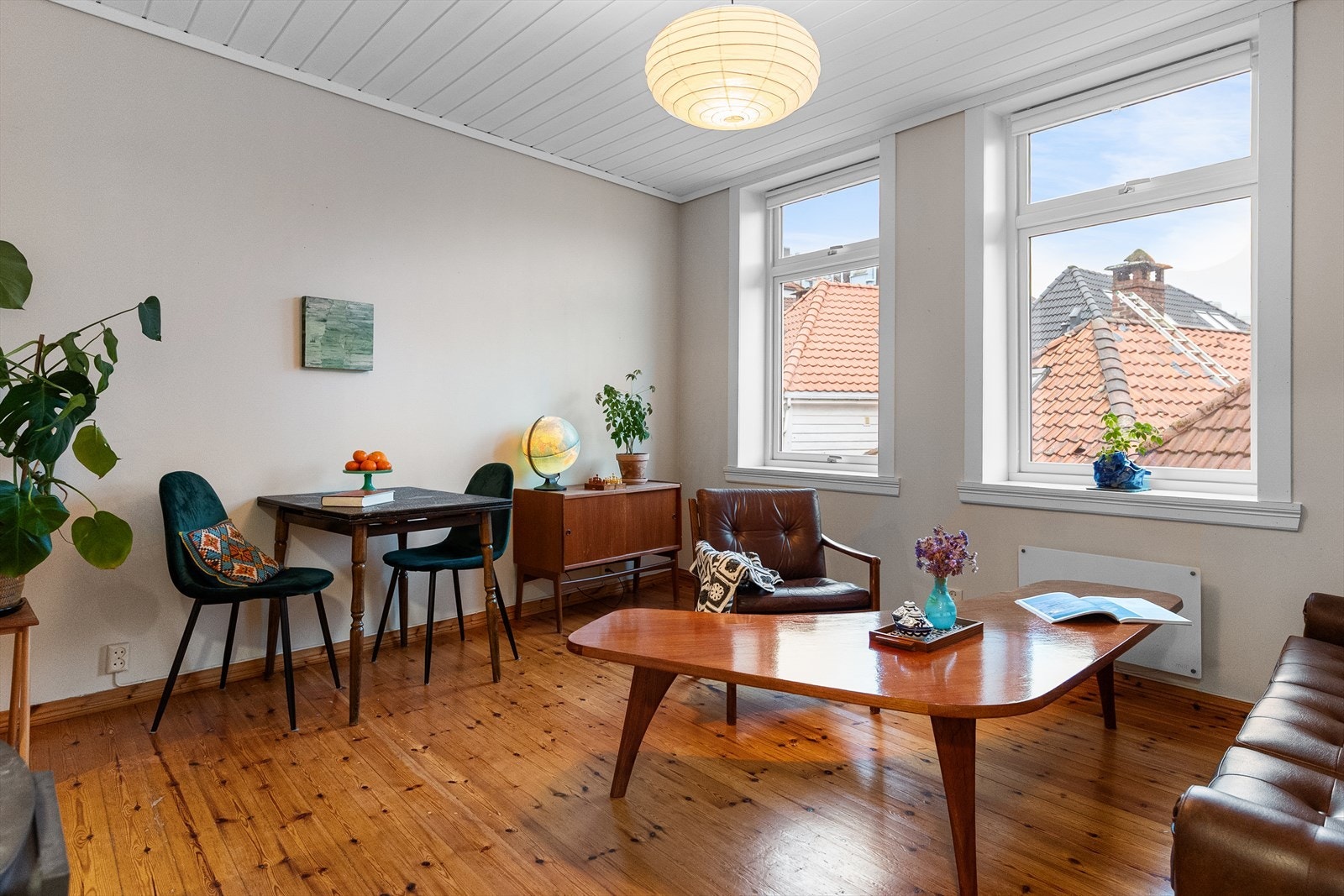 Lys og innbydende stue på 14,4 m² med klassisk furugulv og vedovn som skaper en varm og hyggelig atmosfære. Galleribilde