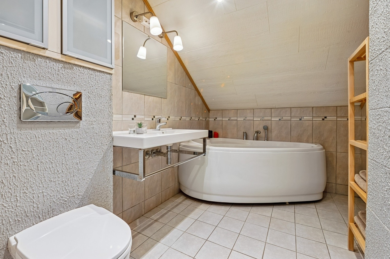 Badet er innredet med veggmontert wc, badekar og mekanisk avtrekk. Galleribilde