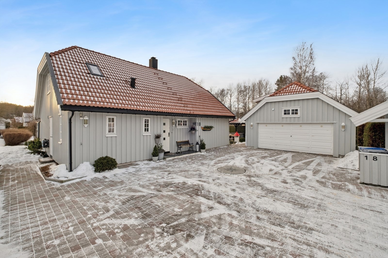 Stor, steinbelagt gårdsplass med god plass til parkering for flere biler. Galleribilde