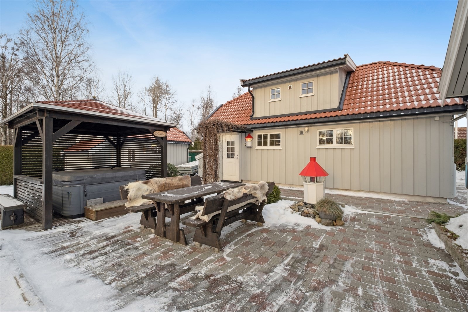 Eiendommen er pent opparbeidet med plen, beplantning og steinlagte uteplasser og gangstier. Galleribilde