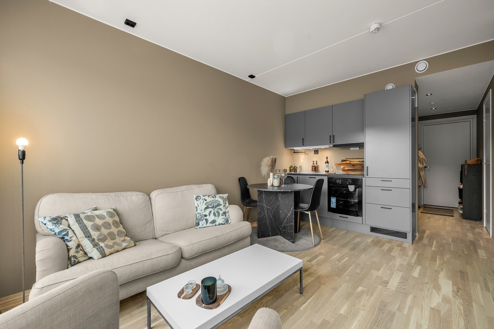 Åpen stue/kjøkkenløsning på 16 m² med plass til spisebord og sofa. Galleribilde