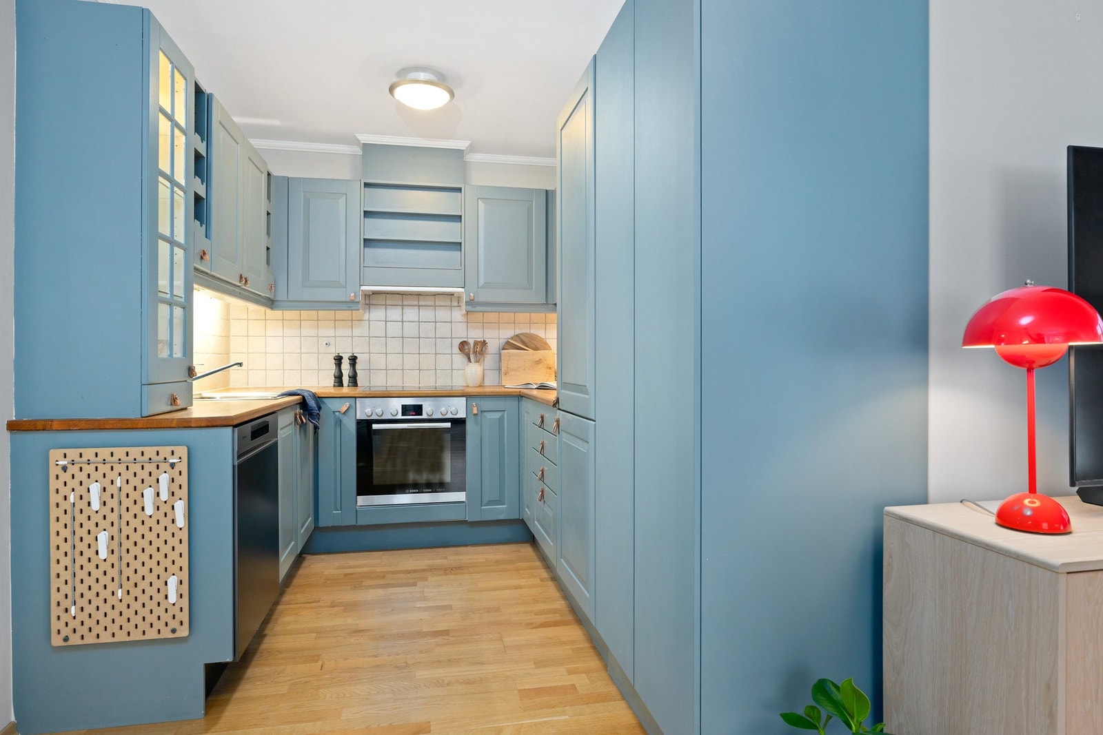 Det er lys under overskap og fliser mellom overskap og benkeplate. videre er kjøkkenet utstyrt med oppvaskmaskin fra 2025, stekeovn, platetopp og kjøl/frys fra 2024 Galleribilde